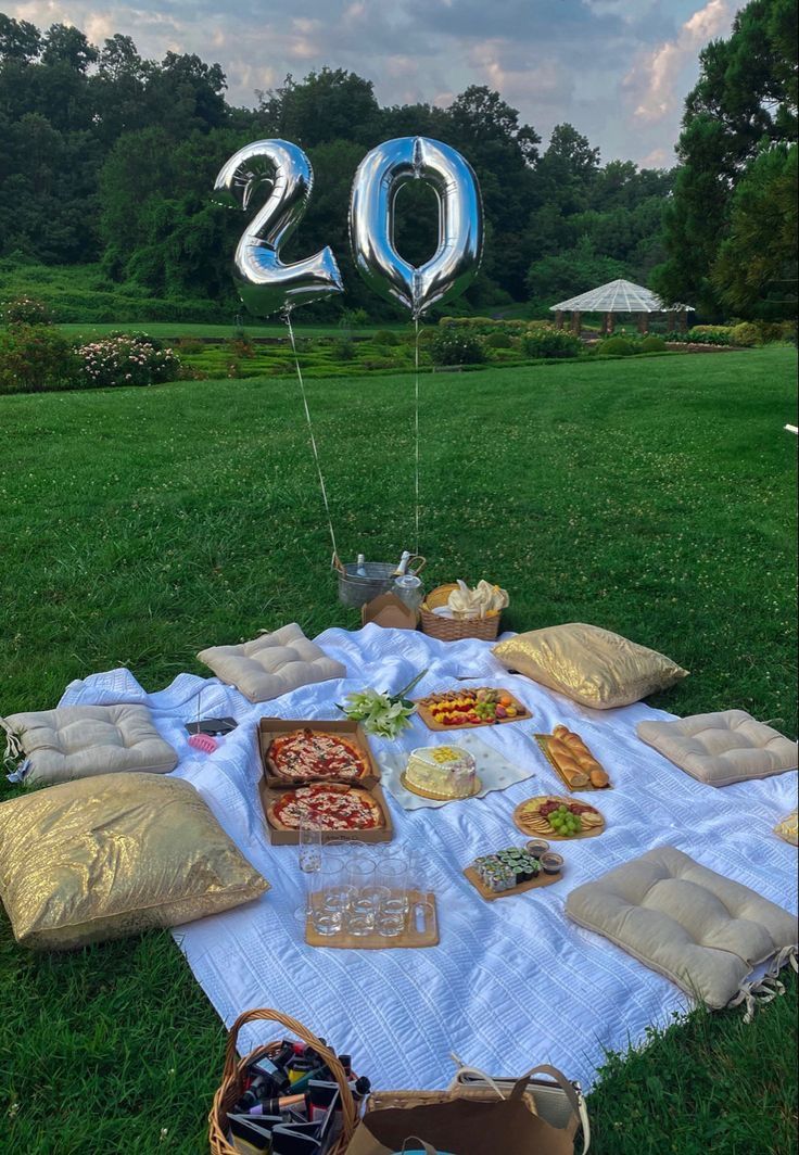 a picnic with food and balloons in the shape of numbers