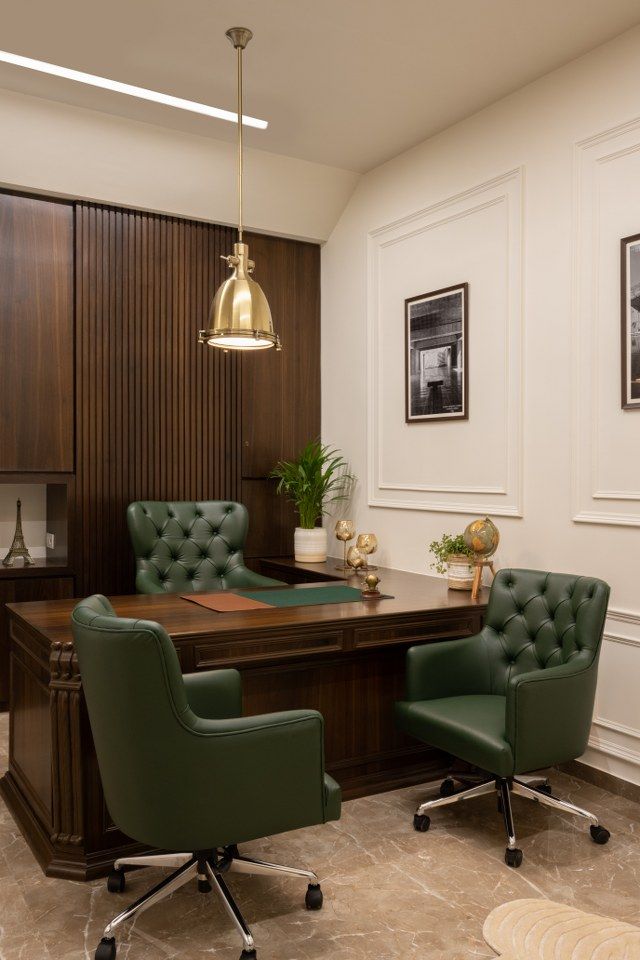 an office with two green chairs and a wooden desk