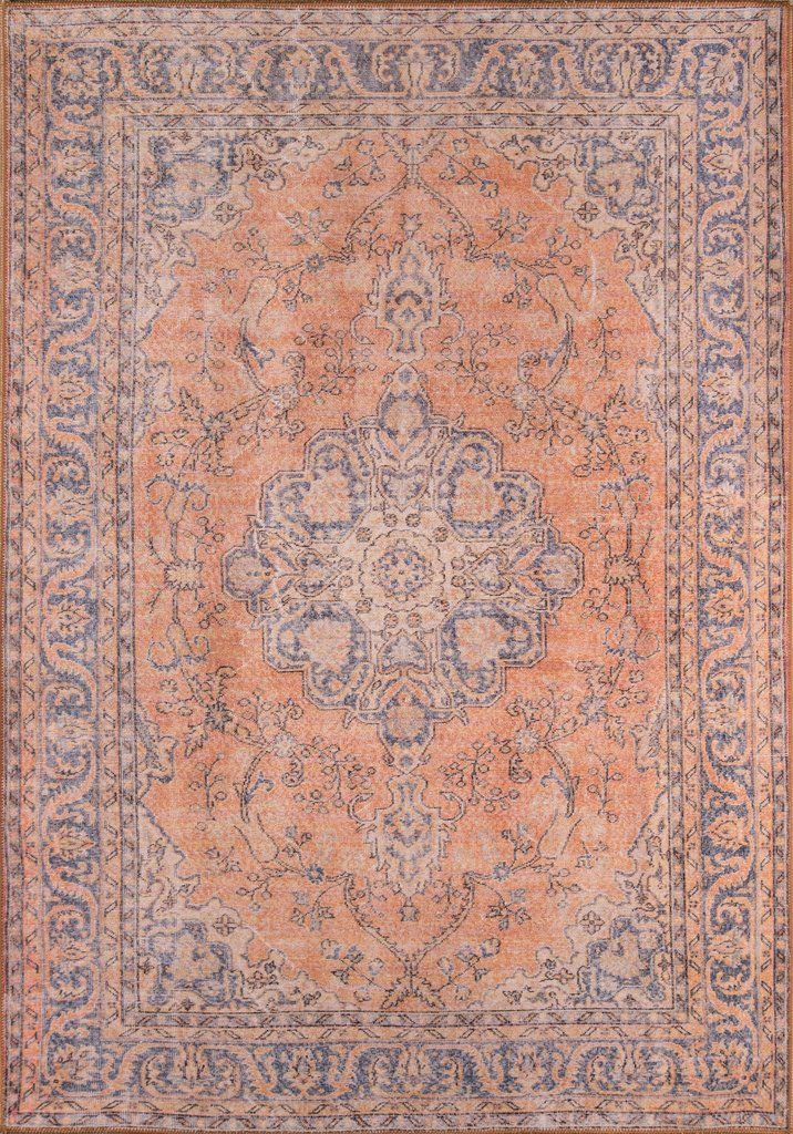 an orange and blue rug with intricate designs on the center, in front of a brown background