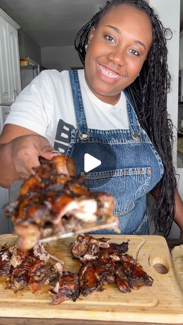 a woman is cutting meat on a wooden board