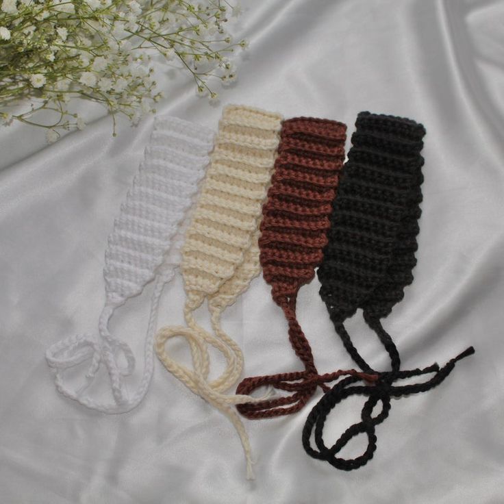 three crocheted headbands laying next to each other on a white sheet