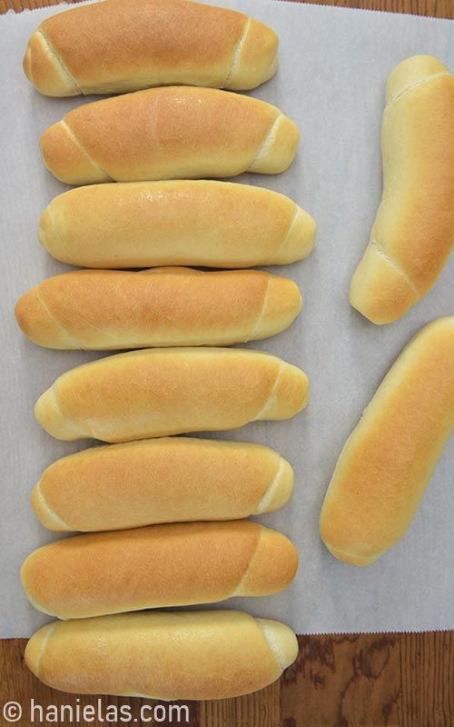 several hot dogs and buns laid out on a piece of paper