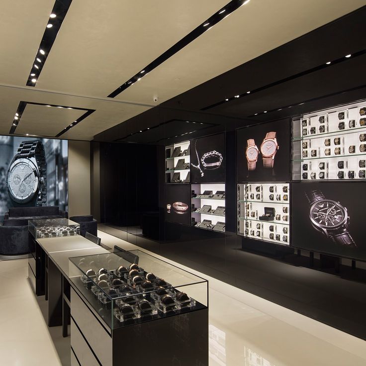 a watch shop with black and white displays on the wall behind glass cases filled with watches