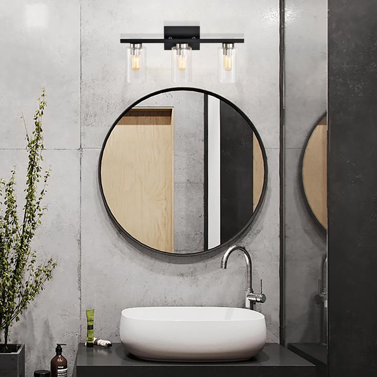 a bathroom sink sitting under a round mirror next to a wooden shelf with vases on it