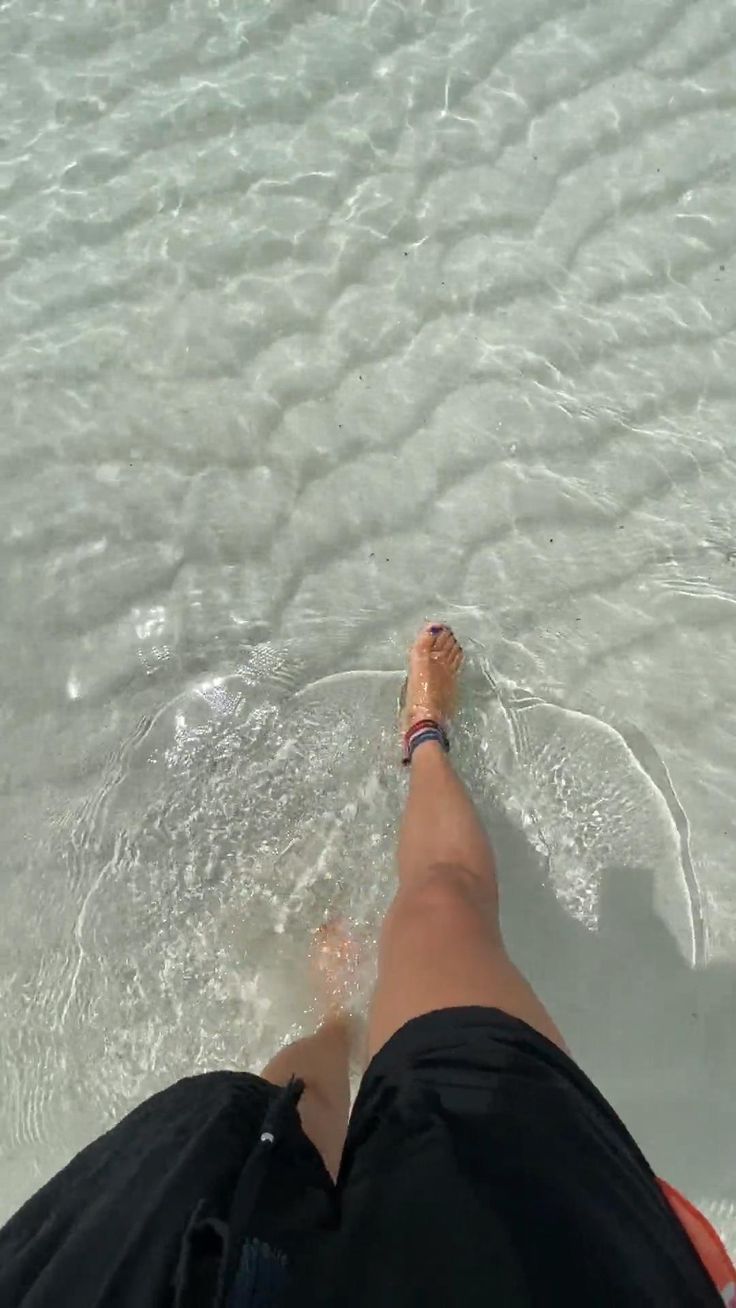 a person's feet in the water at the beach