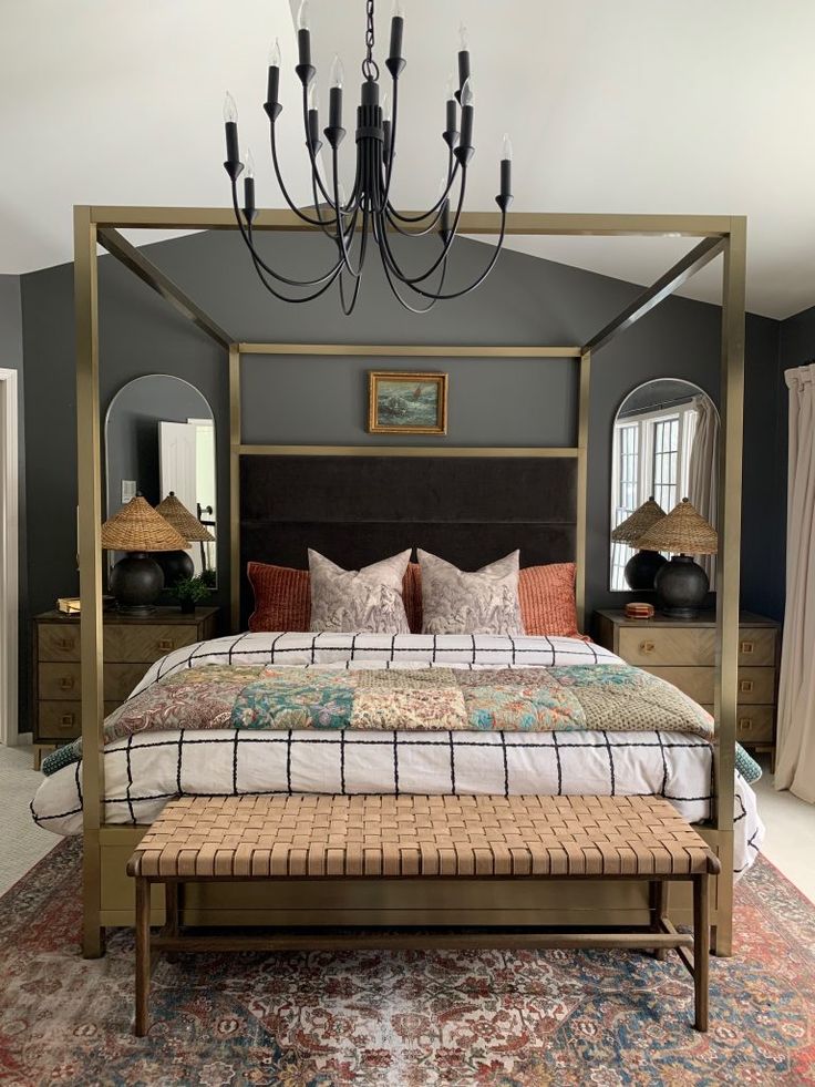 a bedroom with a bed, mirror and chandelier hanging from it's ceiling