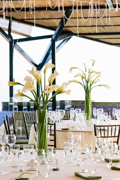 the table is set with many glasses and flowers in vases on top of it