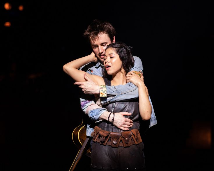 a man and woman embracing each other on stage