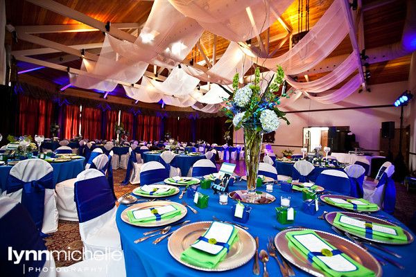 a banquet hall set up with blue and green linens