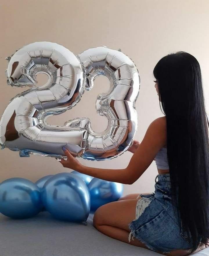 a woman sitting on the floor with balloons in front of her, and the number twenty five