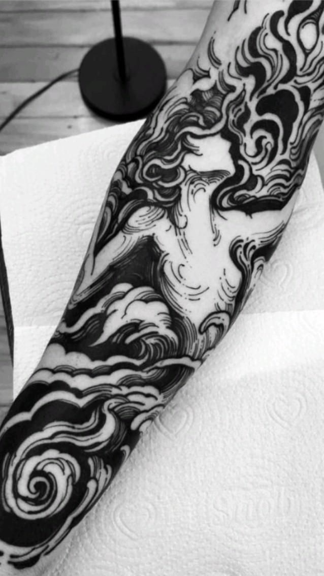 a black and white photo of a person's arm with swirls on it