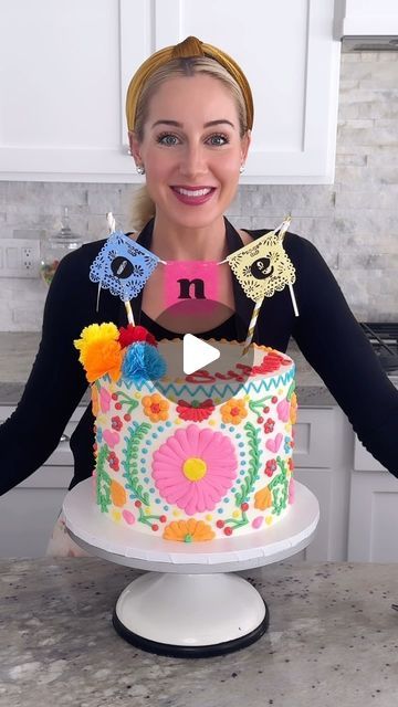 a woman standing in front of a decorated cake