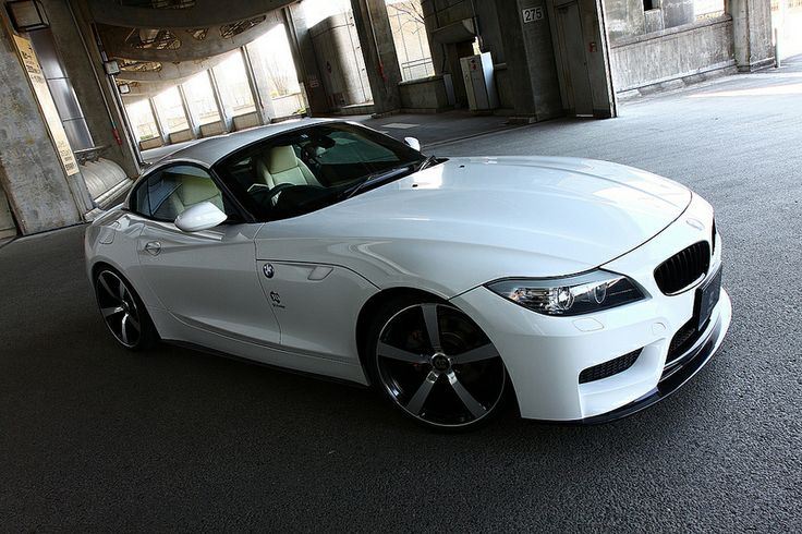 a white sports car parked in an empty parking garage