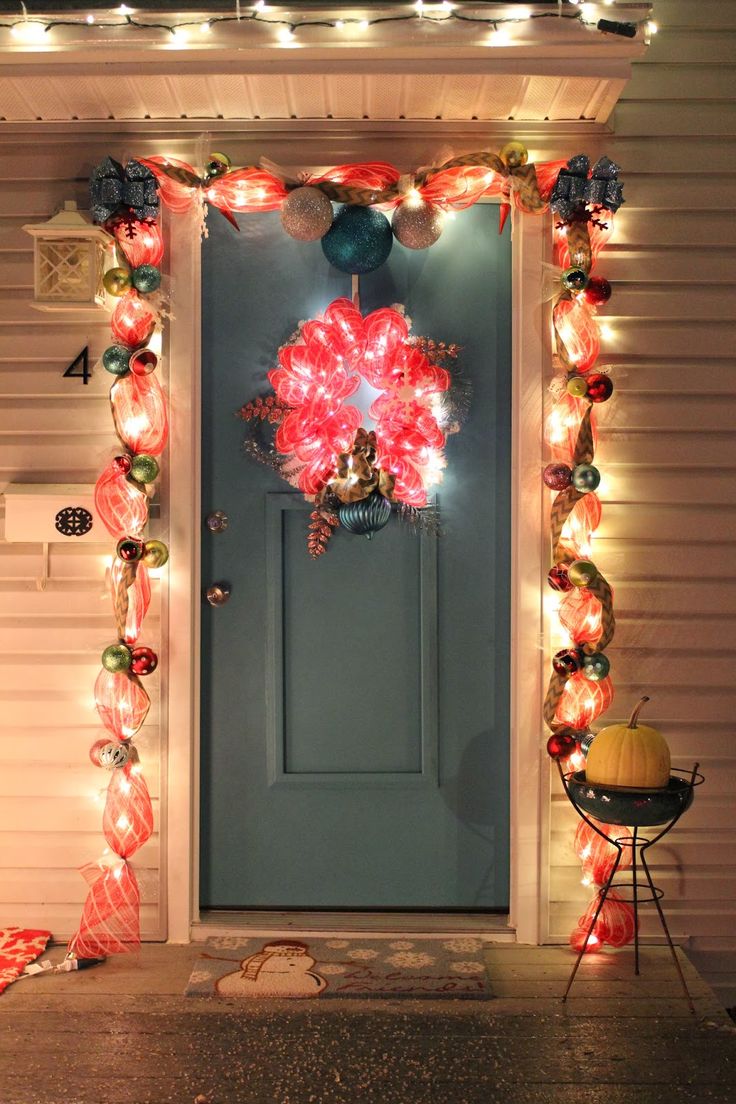 a front door decorated with christmas lights and decorations