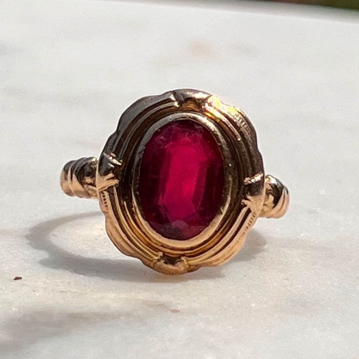 This classic and timeless garnet ring will be an everyday staple. Garnets are so lovely, and this setting augments the stone's beauty wonderfully. The oval garnet measures 6mm x 9mm in a bezel setting. The face sits 14.5 N-S and 13mm E-W, 4mm off the finger. Gorgeous shoulders. Garnet has some wear in accordance with age--there are a couple of scratches and wear along facets as seen under fluorescent light. In excellent condition otherwise!  Sized 5.25 and resizable. Shank narrows to 1.6mm.  Wei Classic Red Ruby Ring, Oval Cabochon, Classic Red Ruby Ring With Oval Cabochon, Classic Garnet Rings With Bezel Setting, Heirloom Garnet Oval Birthstone Ring, Classic Red Rings With Bezel Setting, Classic Red Ring With Bezel Setting, Vintage Oval Garnet Birthstone Ring, Classic Red Bezel Set Ring, Vintage Oval Cabochon Ruby Ring With Polished Finish