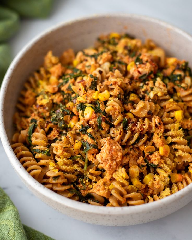 a white bowl filled with pasta and vegetables