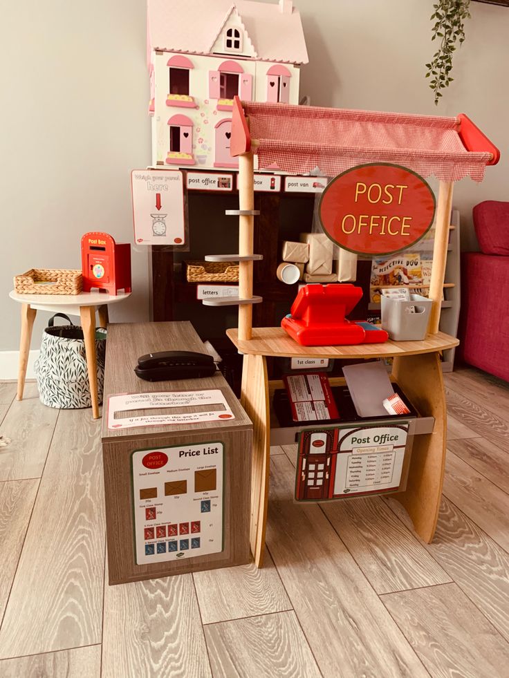 a doll house with furniture and accessories on the floor in front of a red chair