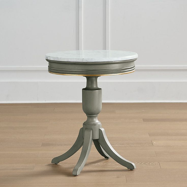 a small table with a marble top on a hard wood floor