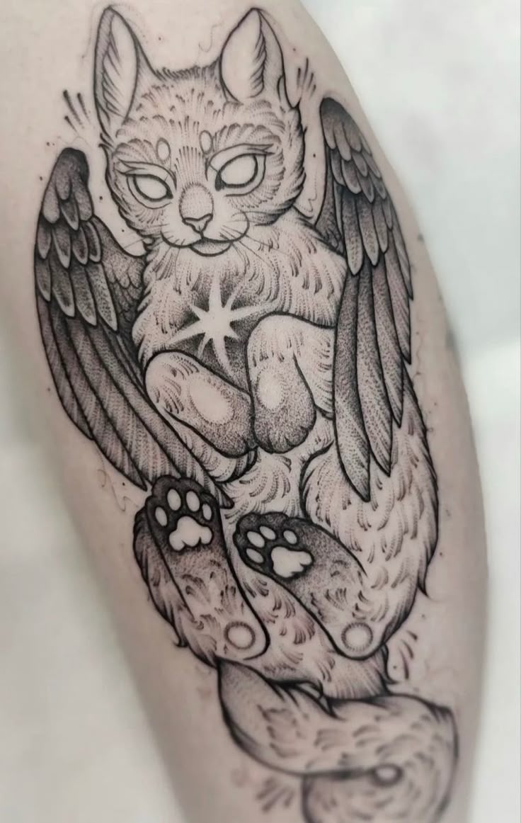 a black and white tattoo design of a cat with wings on it's leg