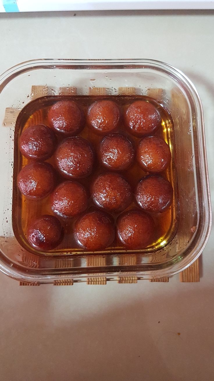 some food is in a glass container on the counter top, ready to be cooked