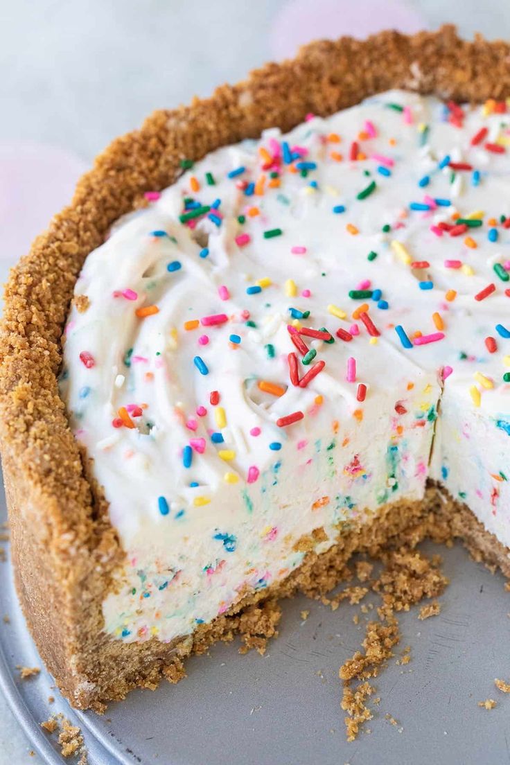 a cake with white frosting and sprinkles sitting on top of a plate