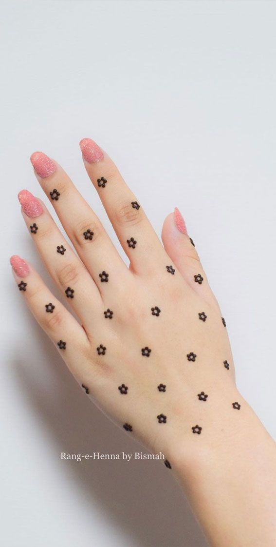 a woman's hand with black dots on it