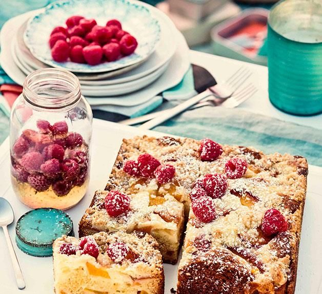 raspberry cake and other desserts on a table with plates, cups and utensils