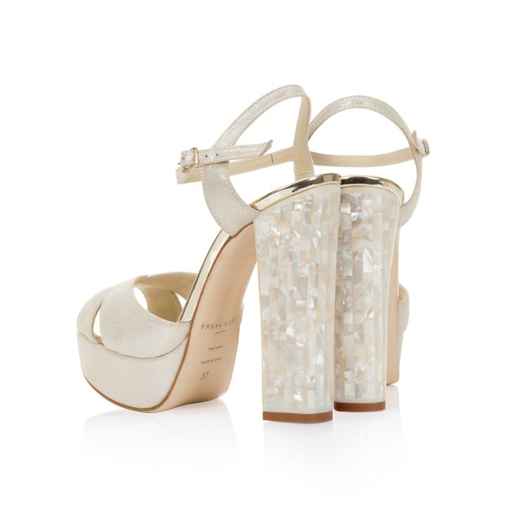 Part of our Iconic collection of contemporary jewelled pearl heels, Bonnie is handcrafted from luxurious ivory shimmer suede, champagne mirrored leather and features our Freya Rose signature genuine mother of pearl heels. Each piece of Mother of Pearl is individually and carefully hand-cut, before being applied to the heel with resin. As a material it is exceptionally durable, and used on the heel of the shoe means they will remain clean and unlikely to damage easily. Our Mother Of Pearl heel ca Shoes For Wedding Guest, Block Heel Wedding Shoes, Brazilian Wedding, Rose Signature, Heels Pearl, Pearl Clutch Bag, Pearl Heels, Unique Shoe, Designer Wedding Shoes