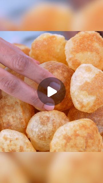 a hand reaching for donuts in a bowl full of doughnut nuggies