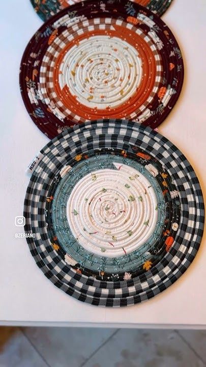 three plates with designs on them sitting on a table