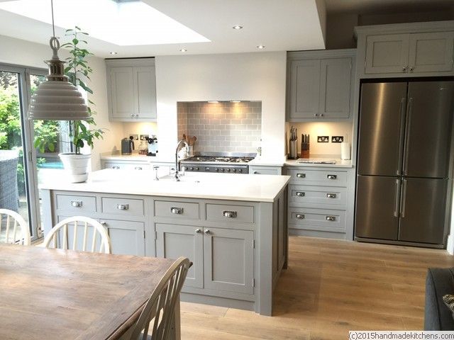 a large kitchen with wooden floors and gray cabinets