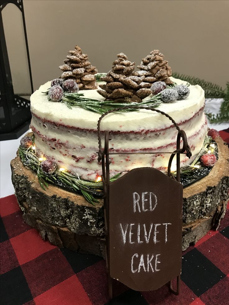 a red velvet cake with pine cones on top and a sign that says red velvet cake