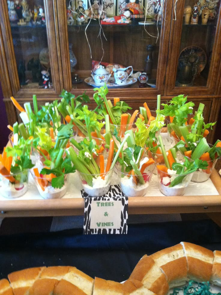 carrots, lettuce and other vegetables in small cups on a table next to bread