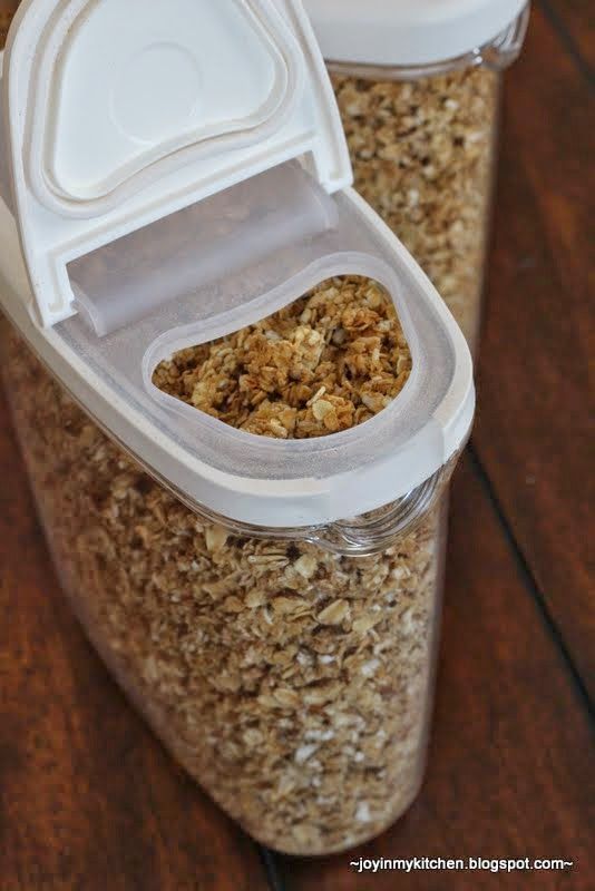 two plastic containers filled with granola on top of a wooden table