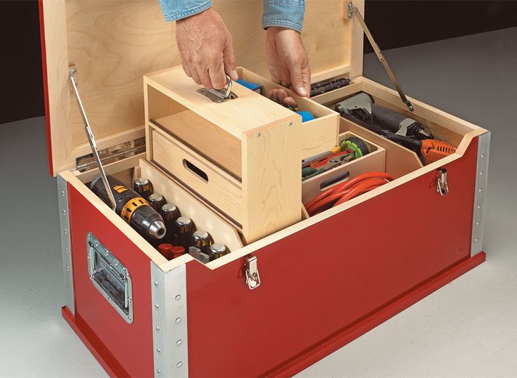 a man is working in an open tool box with tools inside it and his hands are on the drawers