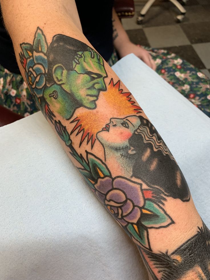 a woman's arm with tattoos on it and an image of a man in the background