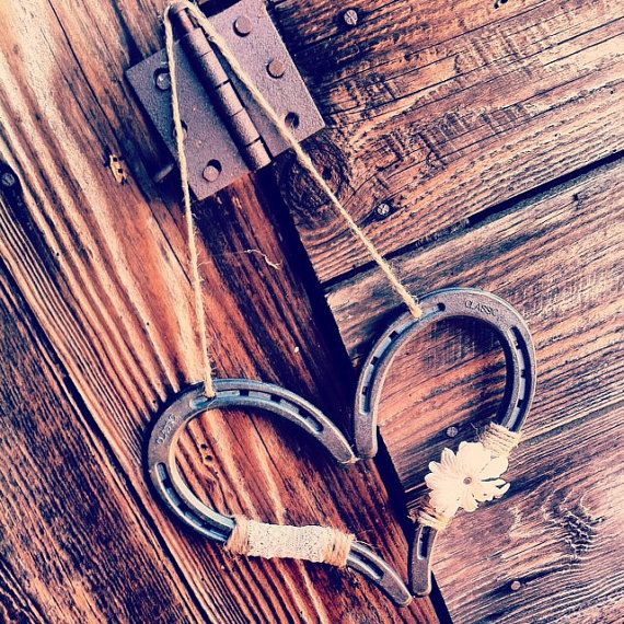 an old pair of scissors hanging from a wooden door with rope and leaves attached to it