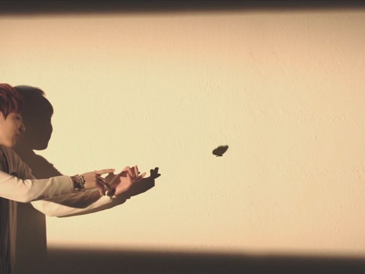 a woman standing in front of a wall with her shadow on the wall