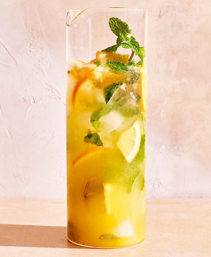 a tall glass filled with lemonade and mint