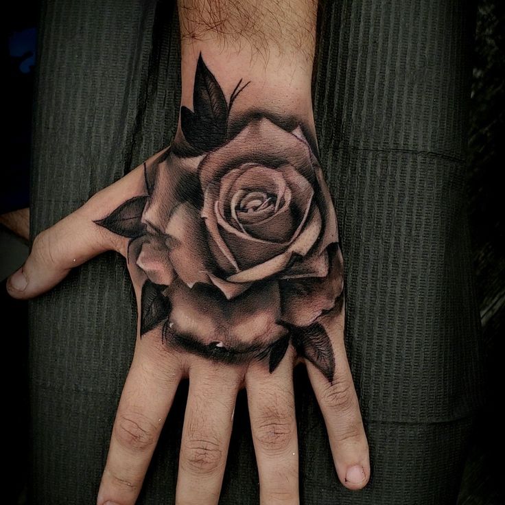 a man's hand with a rose tattoo on it