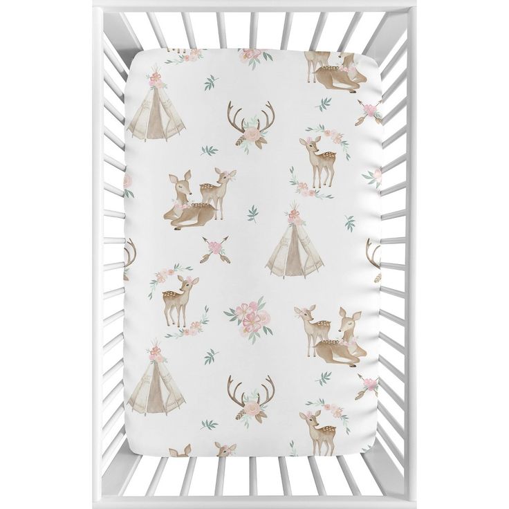 a white crib with deer and flowers on it