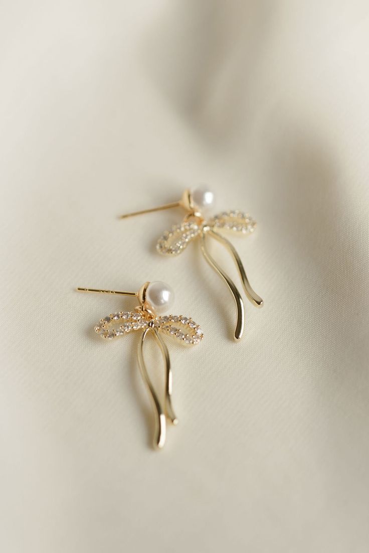 Rumor has is that 2024 is the year of BOWS! These super cute, dangly bow pearl stud earrings will be the HIT of any party. Includes two gold or silver-plated CZ sparkly dangly bow charms 6mm 14k gold-filled or sterling silver, hypoallergenic pearl studs Sparkling Pearl Drop Earrings Gift, Glamorous Drop Pearl Earrings For Gift, Gold Glamorous Jewelry With Bow, Glamorous Gold Jewelry With Bow, Gold Dainty Pearl Earrings For Party, Dainty Gold Pearl Earrings For Party, Gold Pearl Earrings With Bow For Gift, Gold Pearl Earrings With Bow As Gift, Everyday Wear Jewelry