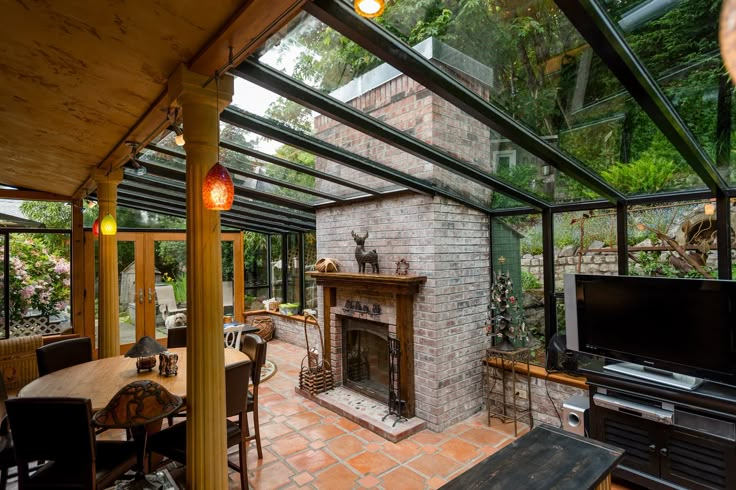 a living room with a fire place sitting under a glass roof