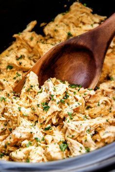 a wooden spoon in a slow cooker filled with food