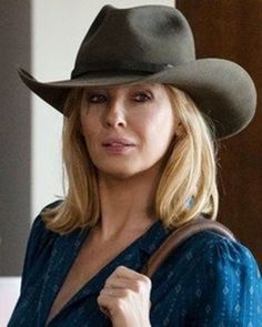 a woman wearing a cowboy hat and looking at the camera