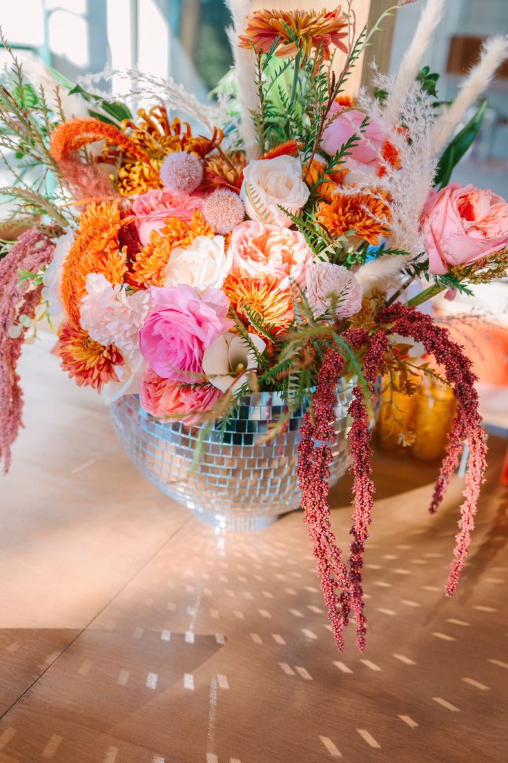 a vase filled with lots of flowers on top of a table