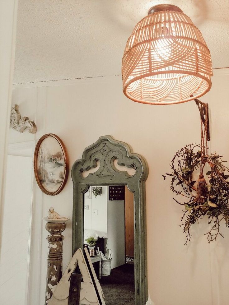 a mirror sitting on top of a wooden table next to a light hanging above it