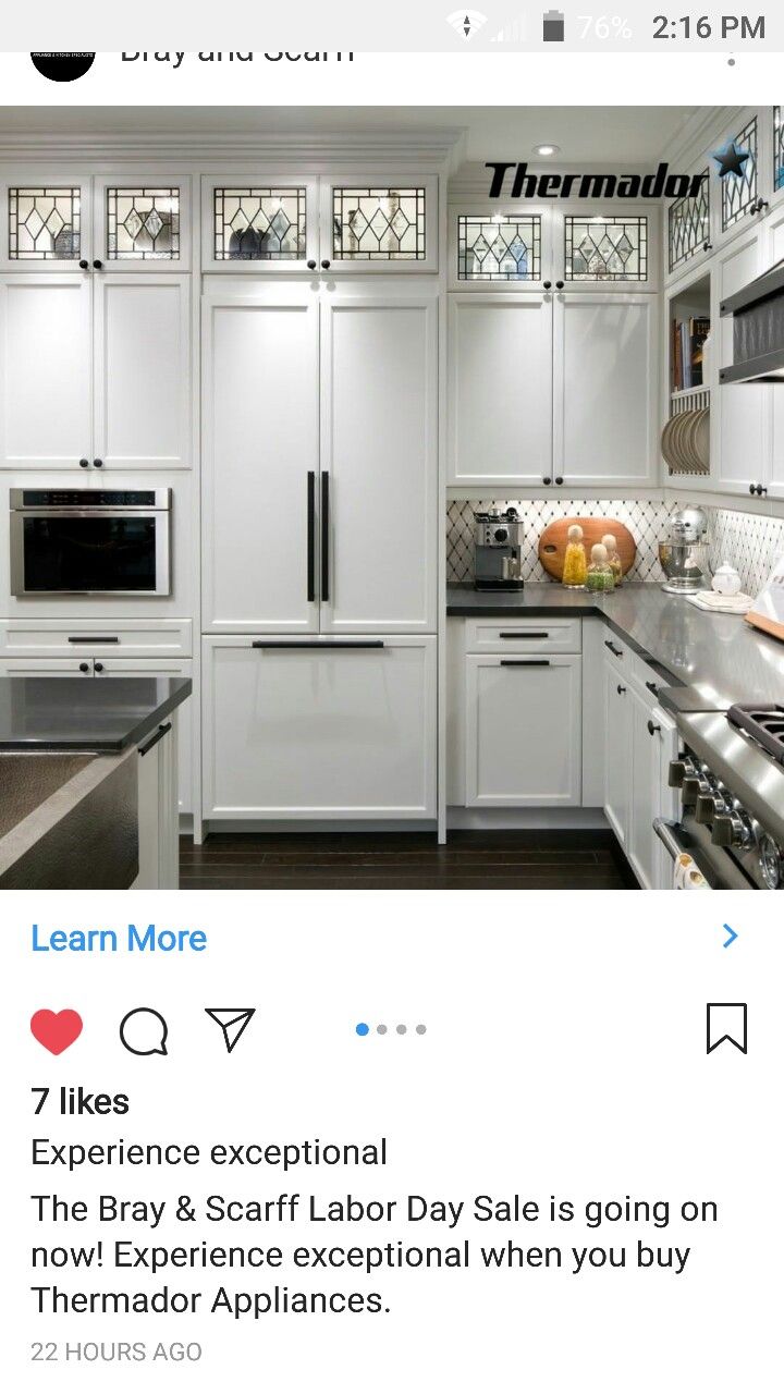 an image of a kitchen with white cabinets and stainless steel appliances on the left side