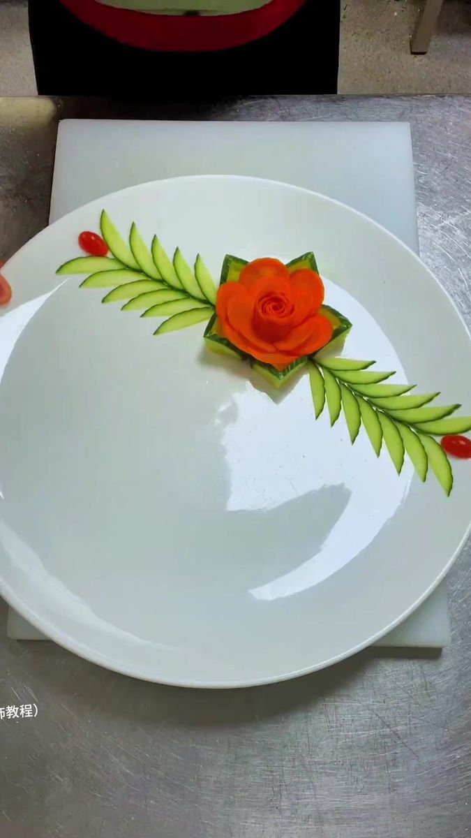 a white plate topped with a red rose and green leaves