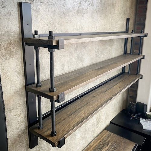 three wooden shelves on the wall with metal brackets attached to them and some wood planks underneath